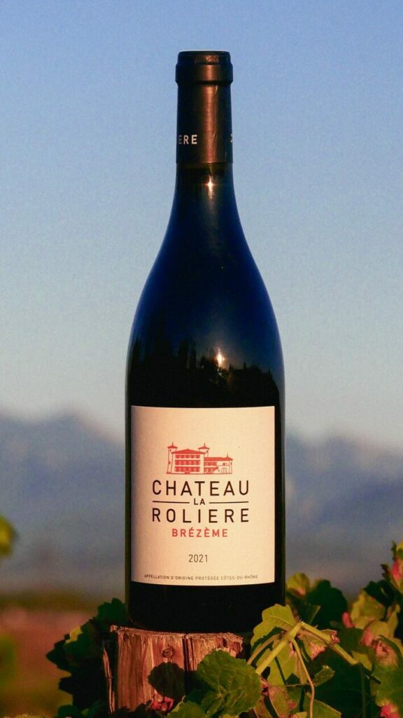 Bouteille de Château La Rolière Brézème dans les vignes. Les trois becs en arrière plan.