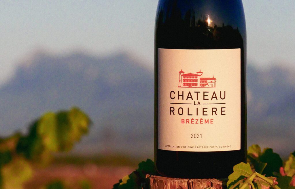 Bouteille de Château La Rolière Brézème dans les vignes. Les trois becs en arrière plan.